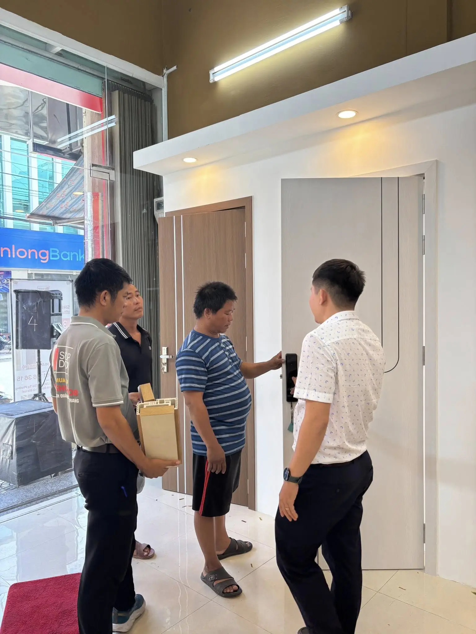 Khách hàng kiểm tra chất lượng cửa composite và khóa vân tay trước khi lắp đặt