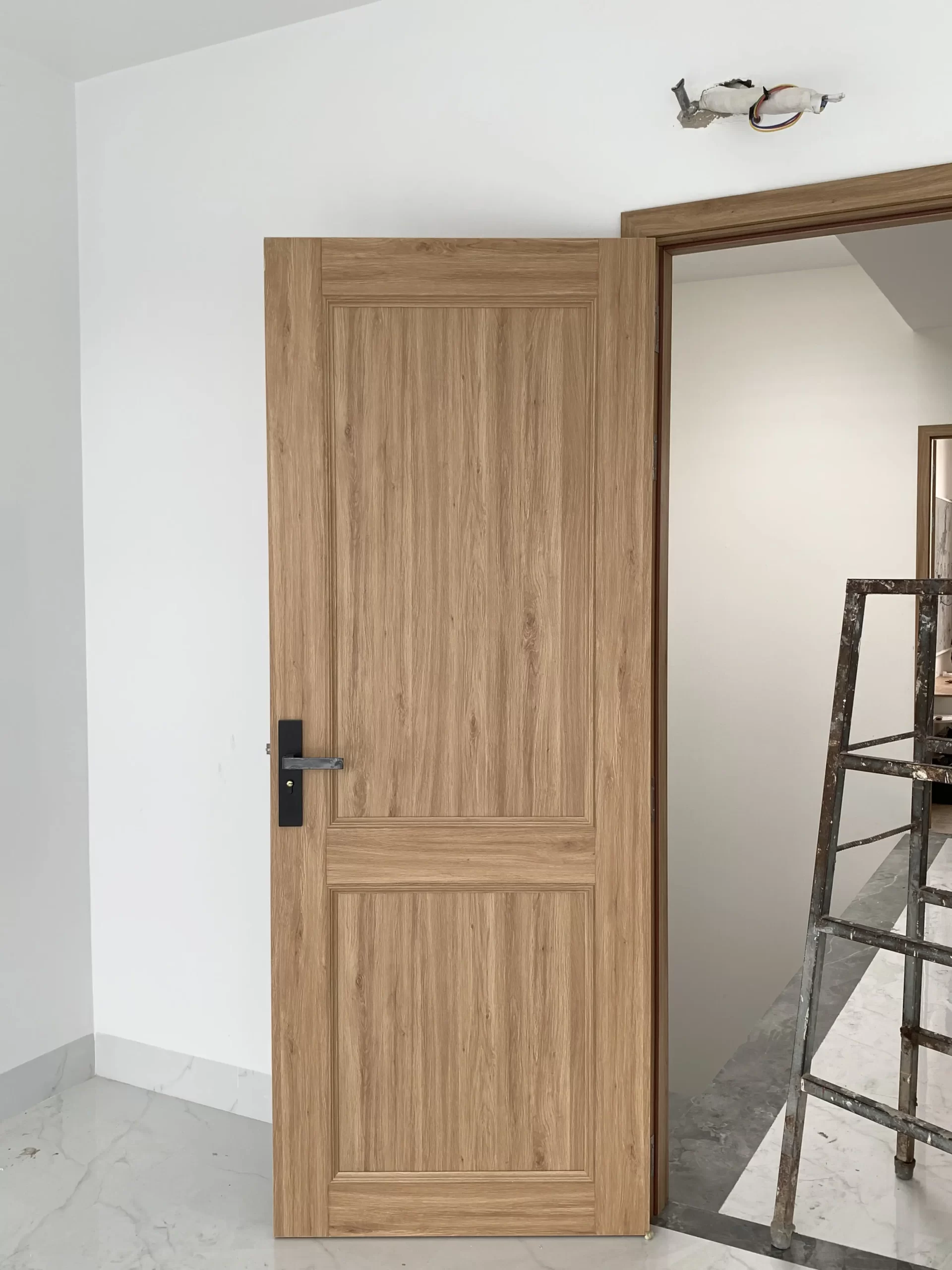 Mẫu cửa composite tone sậm cho phòng ngủ chung cư ấm áp